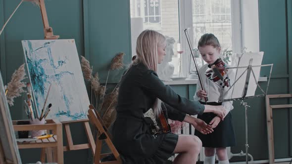 Violin Teacher Puts the Hand of Her Student on the Fretboard