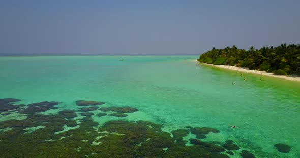 Tropical above tourism shot of a sandy white paradise beach and blue ocean background in colourful 4