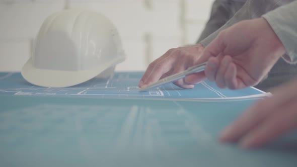 Architect and Engineer in a team discussing house drawings, closeups pointing to a drawing