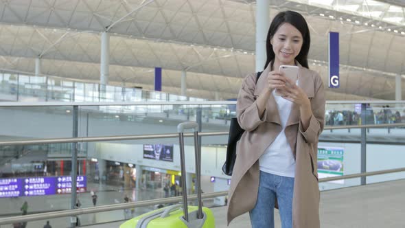Woman working on cellphone in Hong Kong international airport 