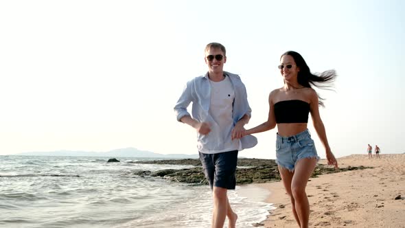 Caucasian sweet couple having fun enjoy relaxing time and running together on beach during summer.