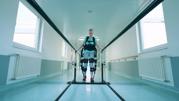 Disabled Woman is Trying to Walk in the Exosuit