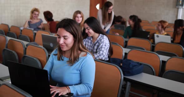 Mature female teacher working with students inside classroom at school university