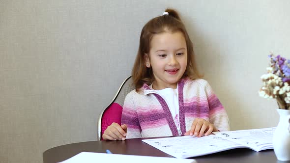 Schoolgirl girl studying homework at home, social distance