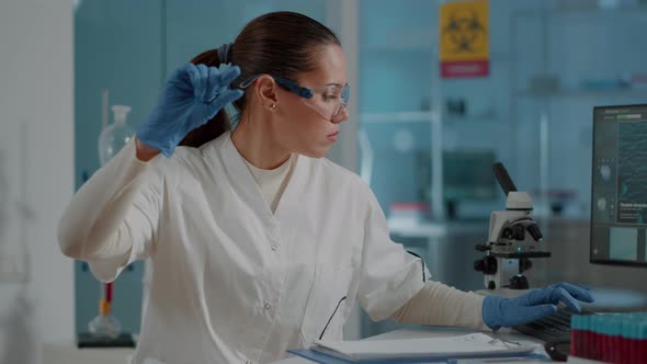 Woman Scientist Looking at Blood Sample on Tray in Laboratory