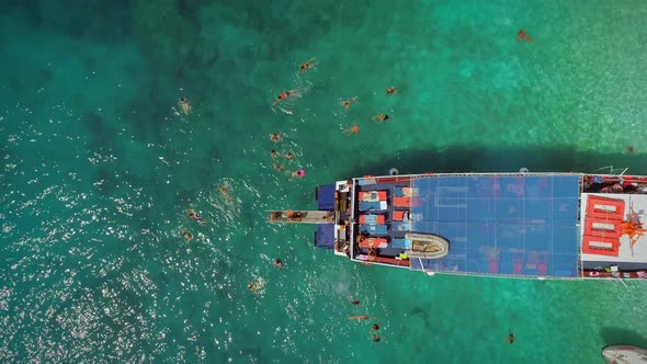 Aerial view of people in ferry diving on the sea, Ithaki island, Greece.