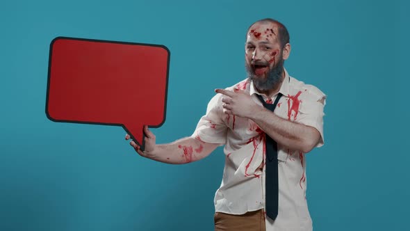 Creepy Mindless Zombie Holding Red Cardboard Speech Bubble on Blue Background