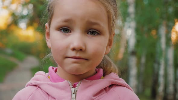 Portrait of Sad Little Girl Looking at Camera