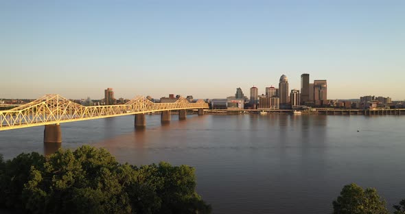 Louisville, Kentucky skyline with bridge and trees with drone video moving down.