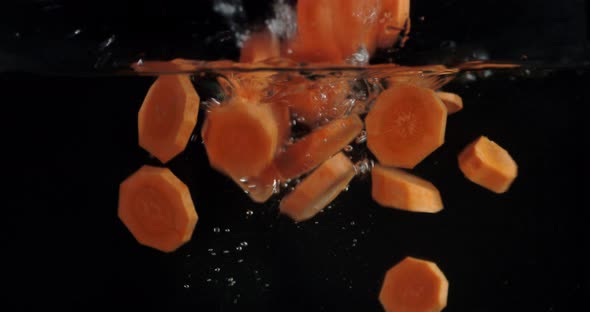 Fall Pieces of Carrot Under Water with Air Bubbles. 