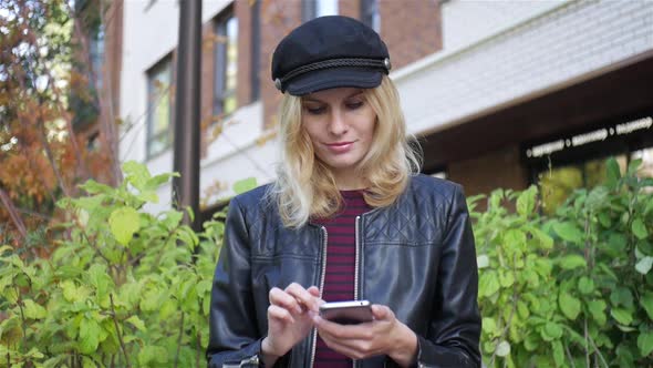 stylish woman with a smartphone sitting on a bench at home