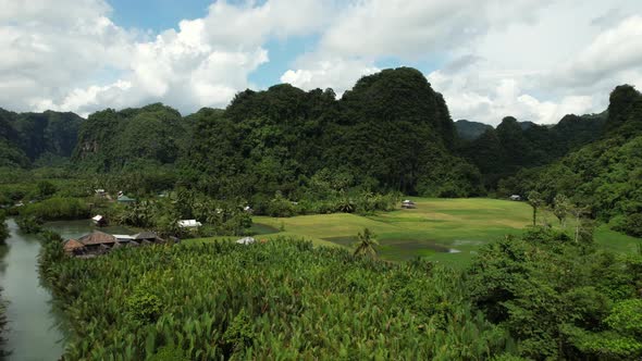 Aerial view of a valley in Ramang Ramang Sulawesi with limestone mountains in the background and a r