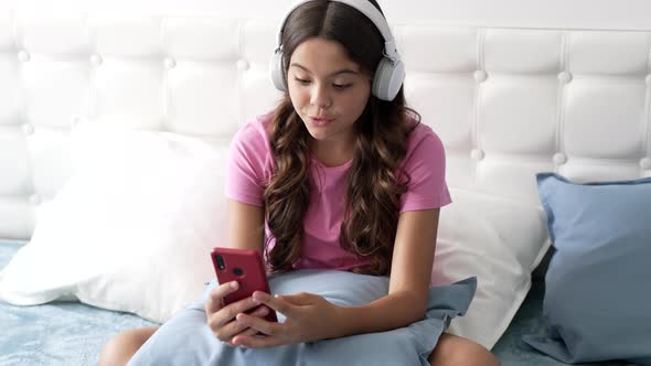 Cheerful Child Blogger Making Video for Weblog in Headphones at Home Conversation