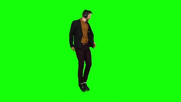 Man in the Headphones Bounces on the Spot and Raises His Hands Up. Green Screen