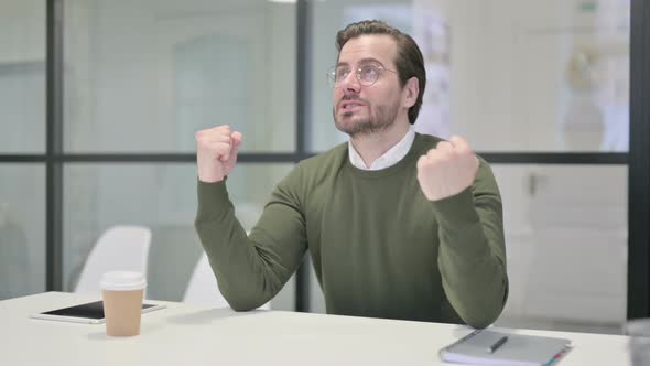 Upset Young Businessman Feeling Worried While Sitting in Office