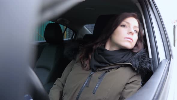 Young Woman Sitting in Car Searching Adress on Street