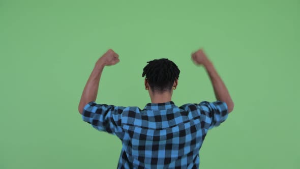 Rear View of Happy Young African Hipster Man with Fists Raised