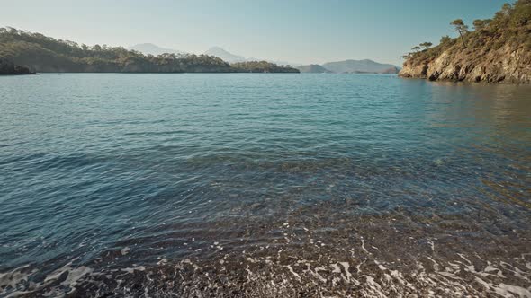Vertical Panoramic Filming of Beautiful Calm Turquoise Sea Water at Wild Solitary Pebble Beach with
