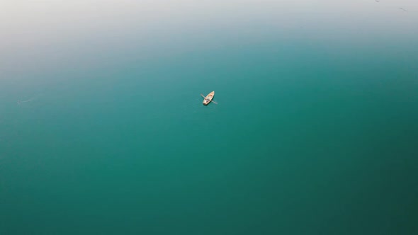 Aerial View Lone Wooden Boat in the Middle of Water Surface of a Mountain Lake