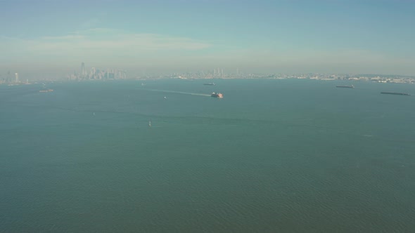Aerial Drone Shot Orbiting Staten Island Ferry in New York Harbor with Skyline