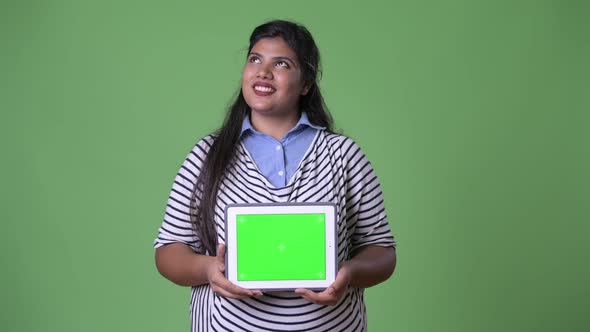 Young Overweight Beautiful Indian Businesswoman Against Green Background