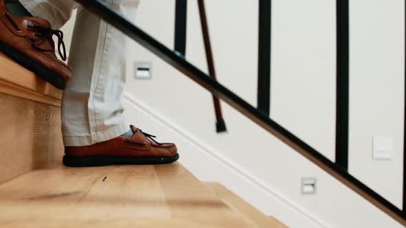 Senior man climbing downstairs with walking stick