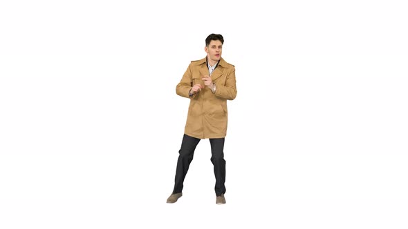 Young Man Wearing Trench Coat Dancing and Having Fun on White Background.