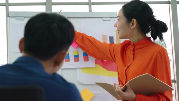 Young Woman Explains Business Data on White Board