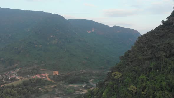 Aerial: flying over rice paddies unique valley scenic cliffs rock pinnacles tropical jungle stunning