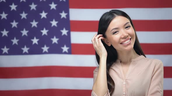 Positive Asian Woman Standing Against USA Flag Background, Independence Day