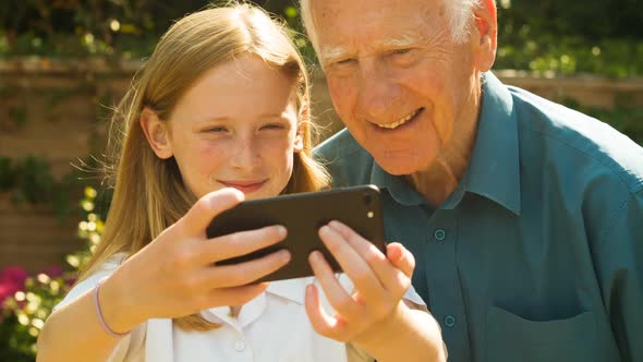 Elderly man and his Grand Daughter taking selfies