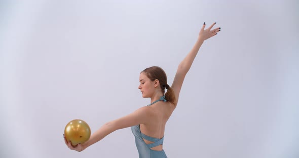 Woman Athlete Performs Callisthenics Exercises with Gymnastic Ball on White Background Sport