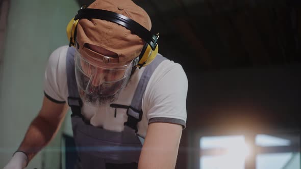 Closeup of Ceramic Worker Using Electric Tile Cutter in Construction Studio