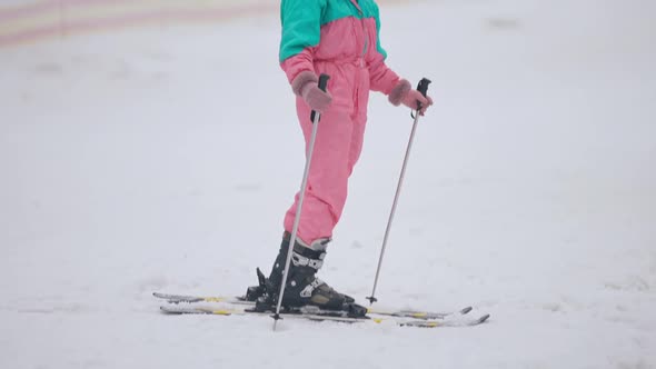 Happy Caucasian Woman Standing on Skis with Ski Poles Looking Around and Smiling