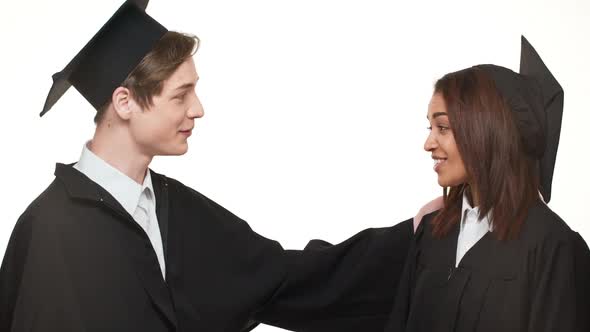 Caucasian Happy Graduate Young Male Giving High Five to Smiling African American Female in Black