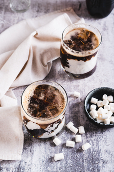 Trendy fluffy coke with marshmallow in  glasses on the table vertical view