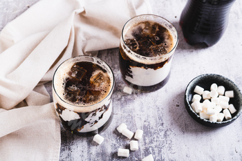 Trendy fluffy coke with marshmallow in  glasses on the table