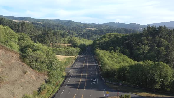Aerial follow of cars driving on scenic highway with beautiful views while on family road trip.