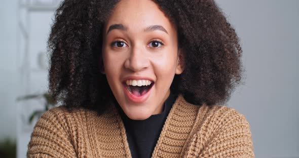 Portrait of Surprised Happy Young Dark Skinned Afro American Girl Female Stands Indoor Glad To