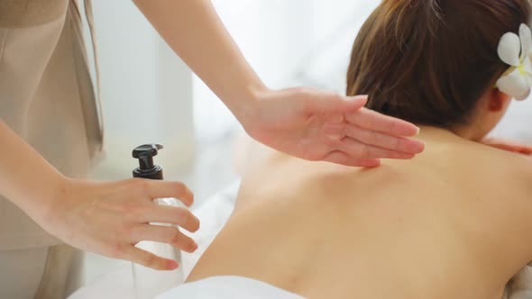 Asian young woman feeling happy and relax during back massage with oil.