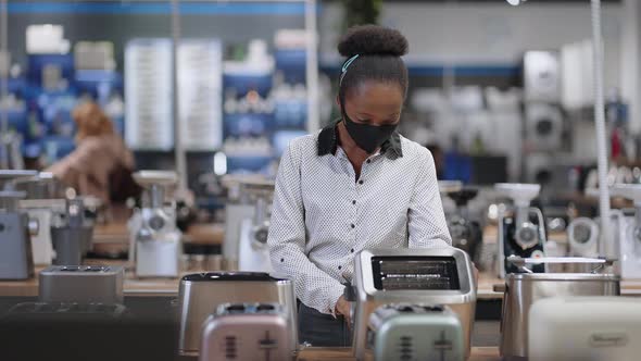 Young Black Housewife is Viewing Toaster in Home Appliance Store Afroamerican Lady is Wearing Face