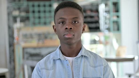 Portrait of Serious Young African Man Looking at Camera