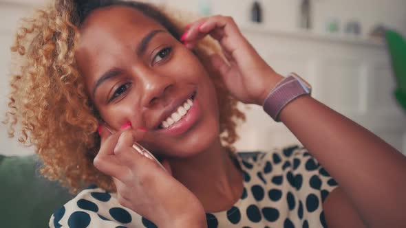 Happy Young African American Woman Joyfully Talking on Mobile Phone