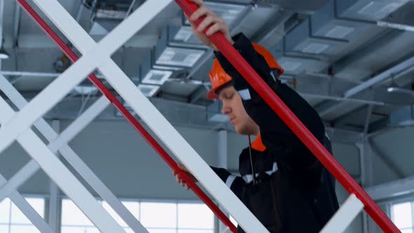 An Industrial Sector Worker Climbs an Iron Ladder Holding Onto the Handrails Inspects Equipment and