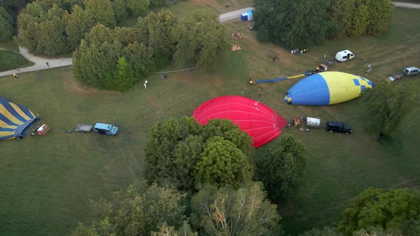 Aerial View of Hot Air Balloons Prepare for an Summer Early Morning Flying in Park in Small European