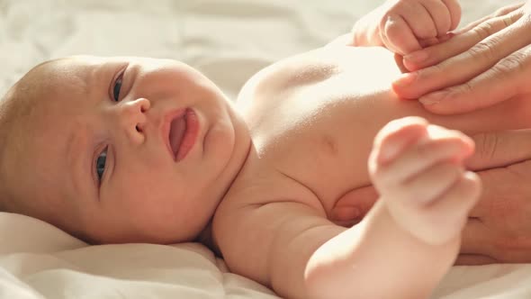 Mother Strokes the Tummy of Newborn Baby