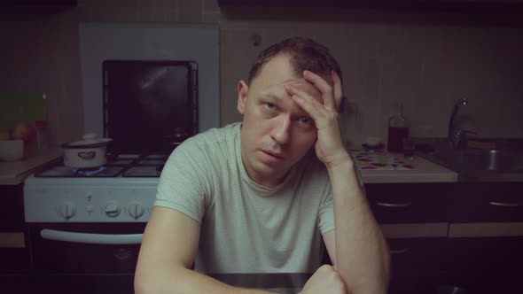 Portrait of a man sitting in the kitchen in the evening, camera movement
