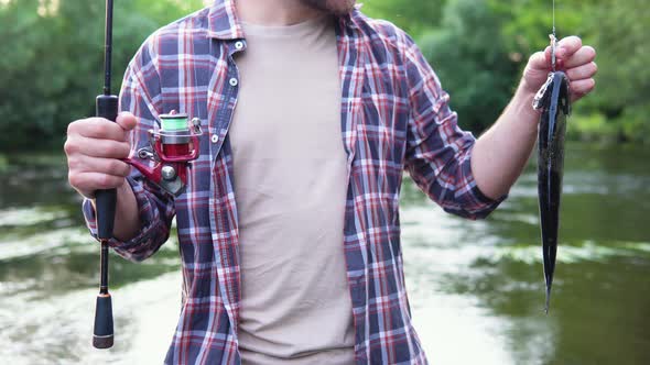 Close Up of Man Holds the Trout Caught in the River