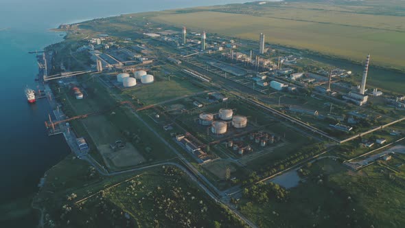 Aerial View of a Chemical Plant Located Between the Harbor and Agricultural Fields at Sunset