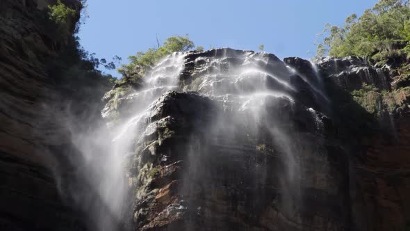 Low angle view of wentworth falls in the blue mountains, Australia with the wind blowing the water c